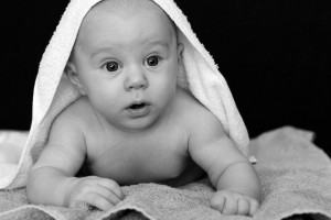 Criança pequena brincando com a toalha
