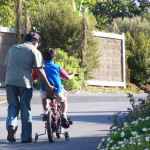 Pai ensinando ao filho a pedalar