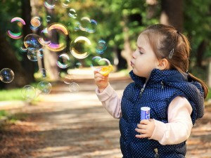 Menina com autismo brincando com bolas de sabão